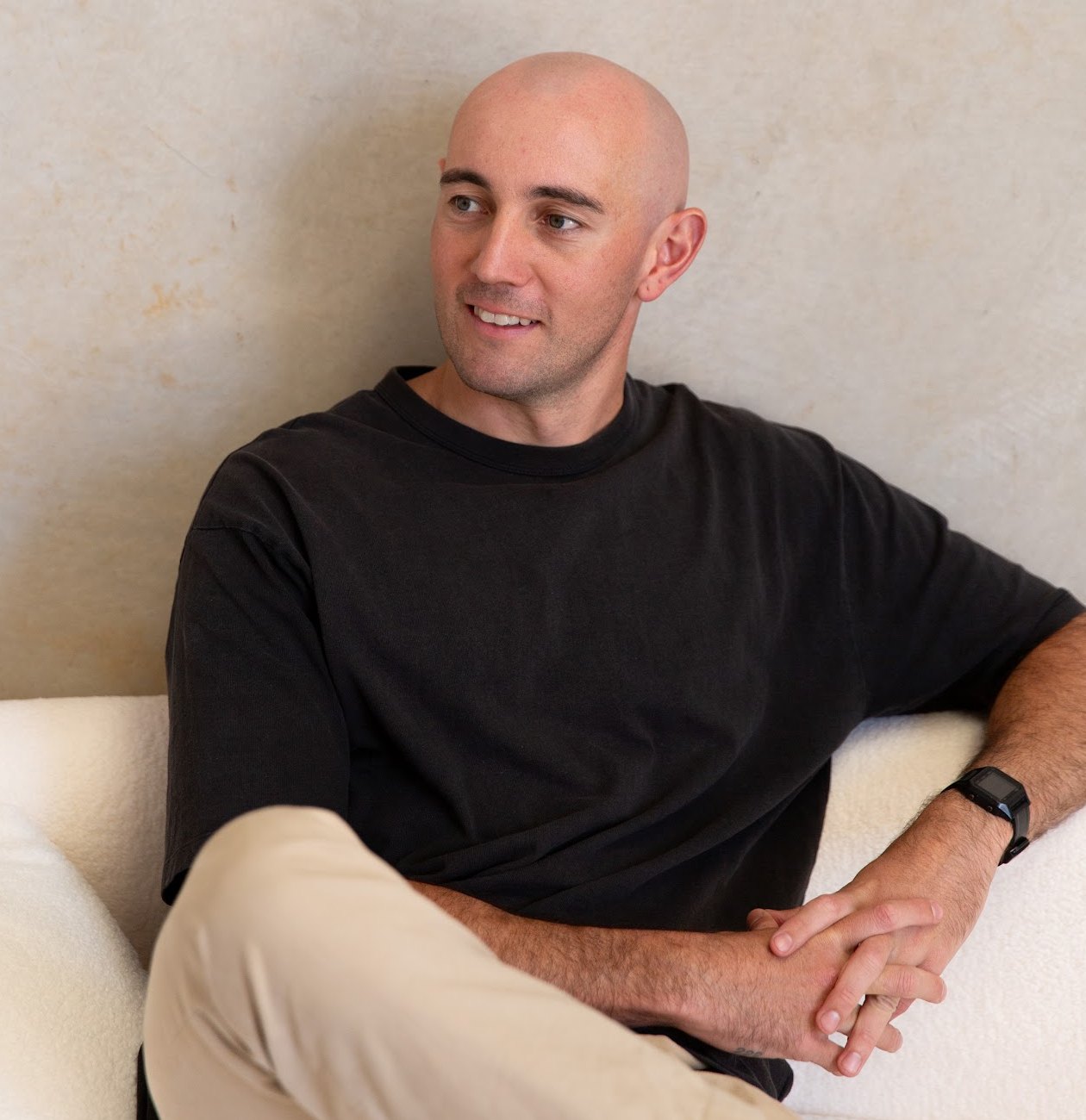 Josh Holliday, seated on a cream sofa.